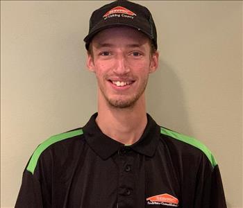 Headshot of Tyler in his SERVPRO uniform shirt and hat