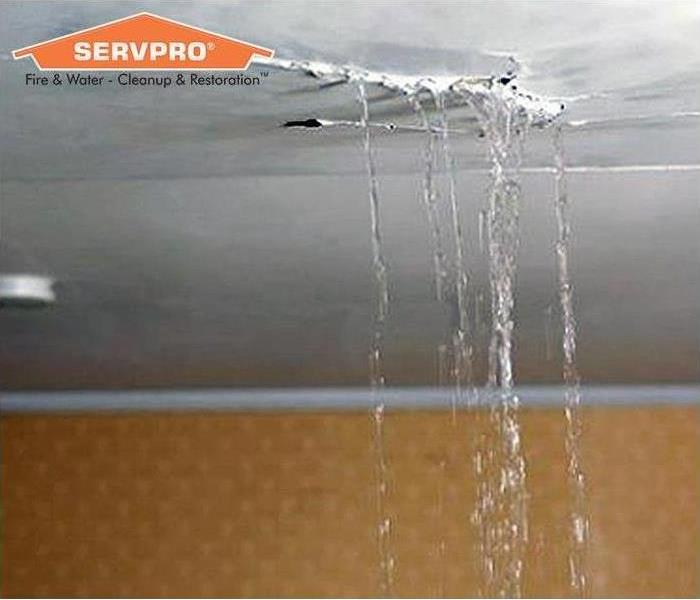 Water leaking from the ceiling with a SERVPRO overlay